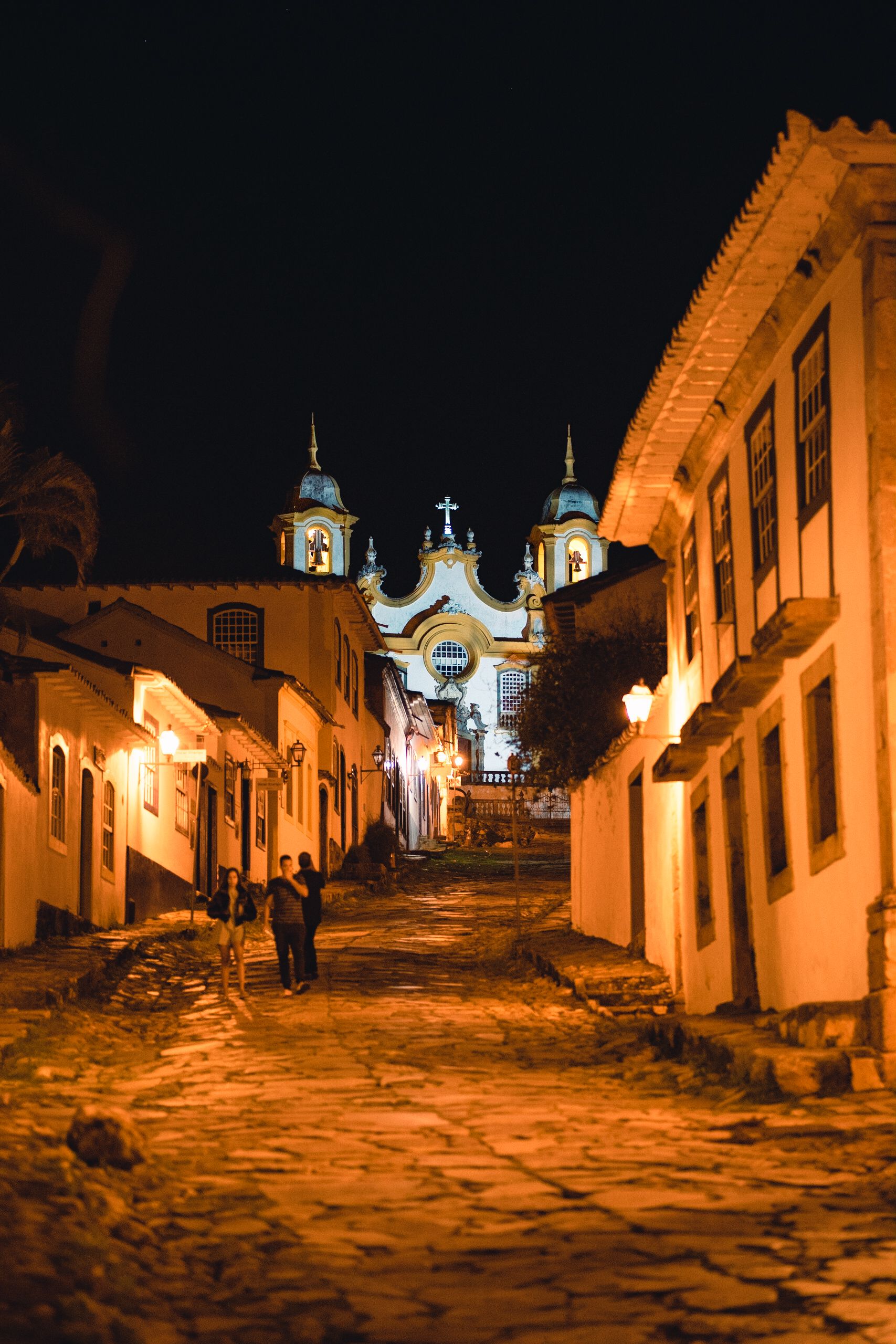Illuminated cobblestone street at night leading to Pirenópolis church